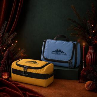 Graue Kulturtasche mit Tragegriff bedruckt mit schwarzem Firmenlogo von Reisenthel, festlich inszeniert als Werbegeschenkidee für Weihnachten