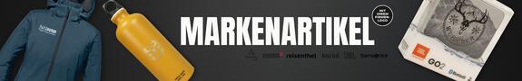 Auf schwarzem Hintergrund sind drei gebrandete Markenartikel zu sehen: eine blaue Softshelljacke mit Logo auf der Brust, eine gelbe Trinkflasche aus Metall mit weißem Aufdruck und ein kompakter Bluetooth-Lautsprecher in Originalverpackung. Daneben steht der Schriftzug „MARKENARTIKEL“ mit Logos bekannter Hersteller.