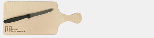 Holzschneidebrett aus Ahornholz mit Logogravur Baust Beckmann Holzbetriebe und Brotzeitmesser mit schwarzem Griff auf neutralem Hintergrund fotografiert