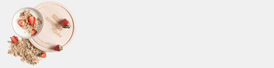 Holzschneidebrett aus Birkenholz mit Logo-Lasergravur von Ehrmann, dekoriert mit Erdbeeren und Haferflocken, auf neutralem hintergrund fotografiert