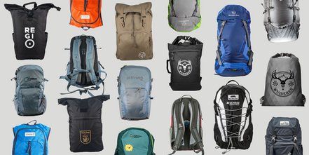 Mehrere Rucksäcke in unterschiedlichen Farben, Formen und Designs sind auf grauem Hintergrund angeordnet. Zu sehen sind Modelle aus Stoff oder Nylon mit verschiedenen Verschlüssen, Tragesystemen und aufgedruckten Logos. Die Rucksäcke variieren zwischen sportlich, funktional und alltagstauglich.