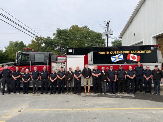 Feuerwehrteam der North Queens Fire Association vor Einsatzfahrzeug im Rahmen einer Spendenaktion der Firma Lerche:.