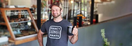 Café-Inhaberin in Kanada mit gebrandeter Werbetasche als Giveaway