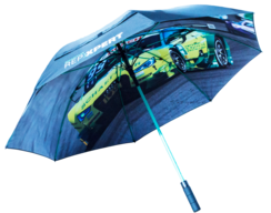 Regenschirm mit schwarzem Griff und Gestänge in Grün. Auf der Schirmfläche ist ein großformatiges Fotomotiv eines gelb-grünen Rennwagens auf einer Rennstrecke sowie ein heller Schriftzug zu sehen.