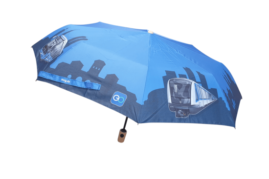 Blauer Taschenschirm mit schwarzem Gestänge und hellem Griff. Auf dem Schirm sind grafische Darstellungen von U-Bahn-Zügen und einer Stadtsilhouette in dunklen Blautönen zu sehen, dazu kleine Logos und eine Webadresse. Blauer Taschenschirm mit schwarzem Gestänge und hellem Griff. Auf dem Schirm sind grafische Darstellungen von U-Bahn-Zügen und einer Stadtsilhouette in dunklen Blautönen zu sehen, dazu kleine Logos und eine Webadresse.