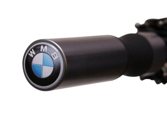 Nahaufnahme eines schwarzen, zylindrischen Griffs mit silbernem Rand. Auf der Stirnseite ist ein rundes Emblem mit schwarzem, weißem und hellblauem Muster sowie Buchstaben zu sehen.