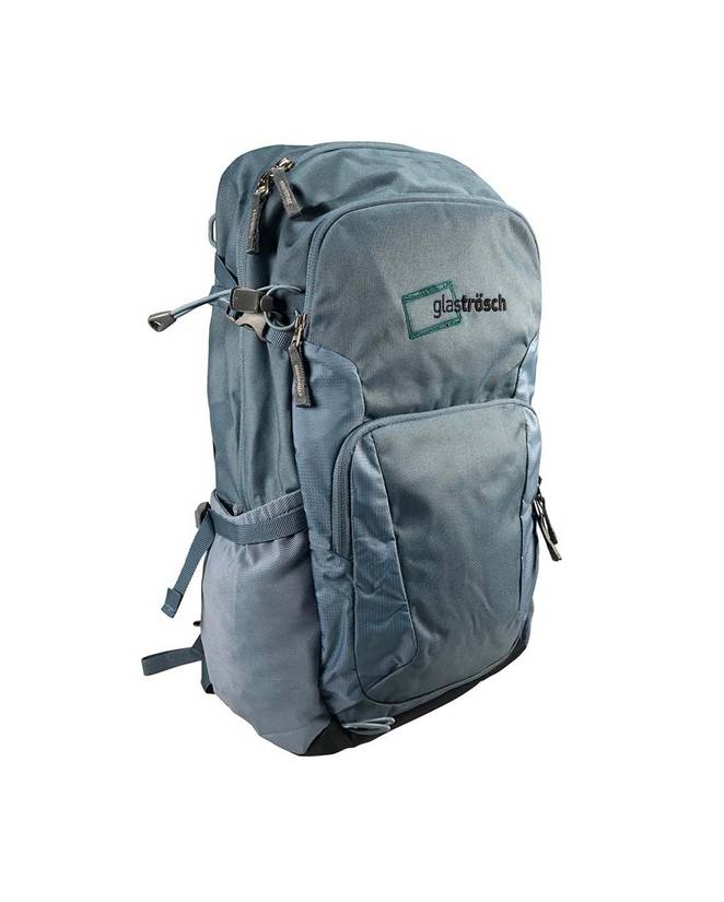 Graublauer Rucksack mit mehreren Reißverschlussfächern, seitlicher Netztasche und verstellbaren Gurten. Auf der Vorderseite ist ein gesticktes Logo mit der Aufschrift „glaströsch“ zu sehen.