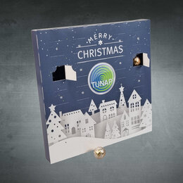 Blauer Adventskalender als Werbemittel mit TUNAP-Firmenlogo, Weihnachtsmotiv und geöffneten Türchen auf grauem Hintergrund fotografiert