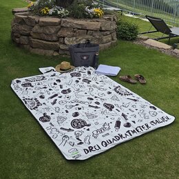 Vollflächig bedruckte Picknickdecke von Gustavo Gusto liegt ausgebreitet auf einer Wiese.