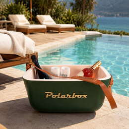 Grüne Polarbox Kühlbox mit Logo auf dem Trageriemen als Werbeartikel mit Sektgläsern und Getränken in einer Szene am Pool.