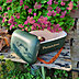 Geöffnete grüne Polarbox mit Wuiderer-Logo, Flasche im Innenraum und braunem Trageriemen auf Holztisch im Garten