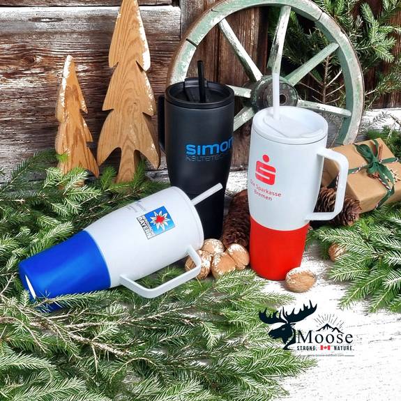 Stimmungsvolles Bild mit drei Logo-Trinkbechern auf Tannenzweigen und weihnachtlicher Dekoration