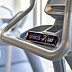 Individuell bedruckter Power X System Proteinriegel mit schwarzem Sports-Day-Werbeschuber auf der Ablage eines modernen Cardiogeräts in einem hellen Fitnessstudio.