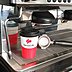 Werbe-Tasse Coffee o Go Becher Wave unter Kaffeemaschine